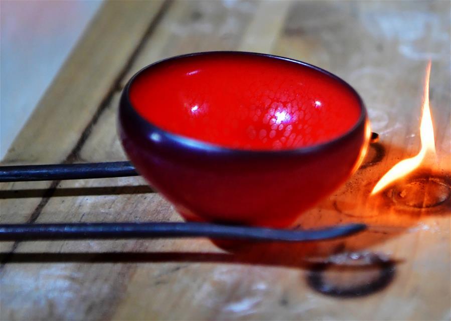 Wu Lizhu, inheritor of the workmanship of Jianzhan teaware, takes a piece of porcelain out from the kiln at his workshop in Jianyang District of Nanping City, south China\'s Fujian Province, March 28, 2019. Jianzhan teaware, a well-known Chinese porcelain originated in Jianyang, dates back to more than 1,000 years ago in Song dynasty (960-1279). It was the best teaware for scholars and literati to use during that time in tea competitions. Jianzhan teawares are known for their variability. Glazes can range in color from dark plum to yellow, green, and blue. During the heating and cooling processes, iron element in the clay can migrate within the glaze to form surface crystals in rich and glossy colors, as in the \