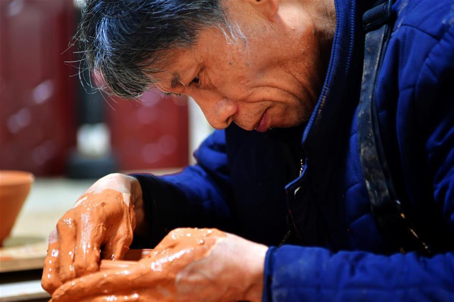 Wu Lizhu, inheritor of the workmanship of Jianzhan teaware, makes a piece of porcelain at his workshop in Jianyang District of Nanping City, south China\'s Fujian Province, March 28, 2019. Jianzhan teaware, a well-known Chinese porcelain originated in Jianyang, dates back to more than 1,000 years ago in Song dynasty (960-1279). It was the best teaware for scholars and literati to use during that time in tea competitions. Jianzhan teawares are known for their variability. Glazes can range in color from dark plum to yellow, green, and blue. During the heating and cooling processes, iron element in the clay can migrate within the glaze to form surface crystals in rich and glossy colors, as in the \