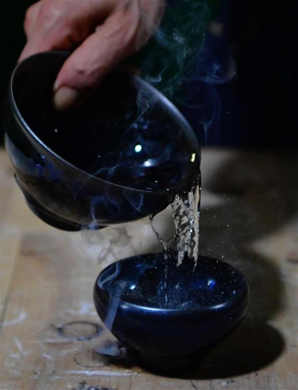 Wu Lizhu, inheritor of the workmanship of Jianzhan teaware, cools a piece of porcelain at his workshop in Jianyang District of Nanping City, south China\'s Fujian Province, March 28, 2019. Jianzhan teaware, a well-known Chinese porcelain originated in Jianyang, dates back to more than 1,000 years ago in Song dynasty (960-1279). It was the best teaware for scholars and literati to use during that time in tea competitions. Jianzhan teawares are known for their variability. Glazes can range in color from dark plum to yellow, green, and blue. During the heating and cooling processes, iron element in the clay can migrate within the glaze to form surface crystals in rich and glossy colors, as in the \