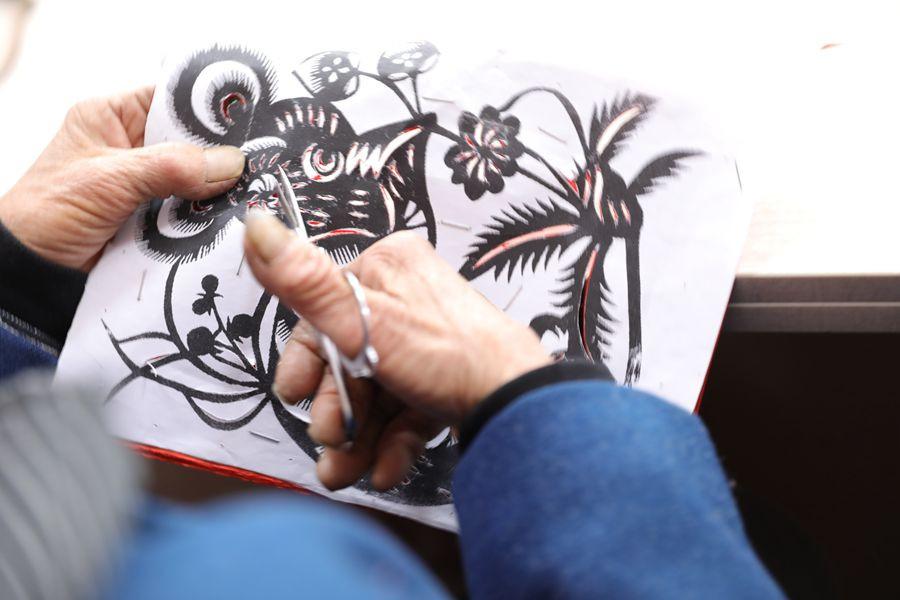 A woman makes a paper-cutting on March 28, 2019, in Fengning Manchu autonomous county, Hebei province.(Photo by Fu Rui/chinadaily.com.cn)