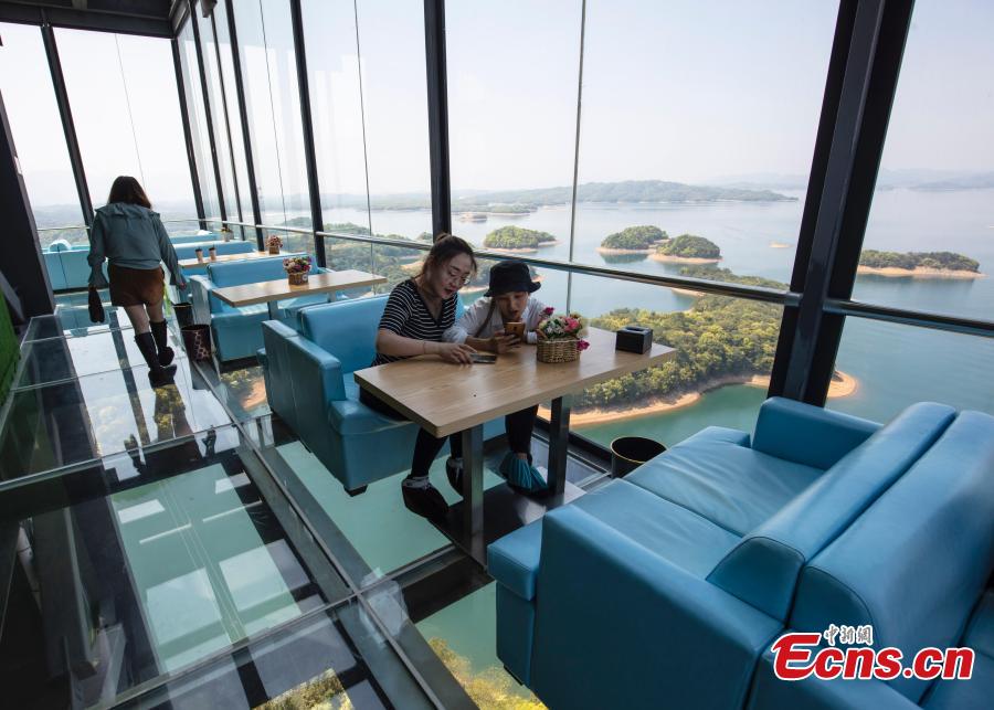 A view of a café inside a glass sightseeing tower, 99 meters above the ground, in Lushan Xihai scenic area in Yongxiu County, East China\'s Jiangxi Province, April 7, 2019. Visitors to the tower can enjoy great views of the mountain and lake. (Photo: China News Service/Zhang Haiyan)