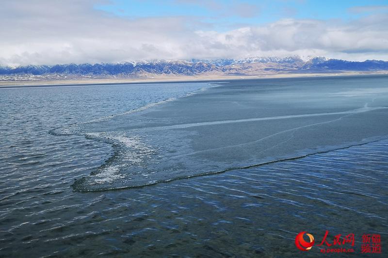 Photo shows thawing ice on the surface of Sayram Lake in northwest China\'s Xinjiang Uyghur Autonomous Region. The swans, the high mountains, the clear water and the blue sky have turned the lake into a spring fairyland.  (Photo/people.cn)