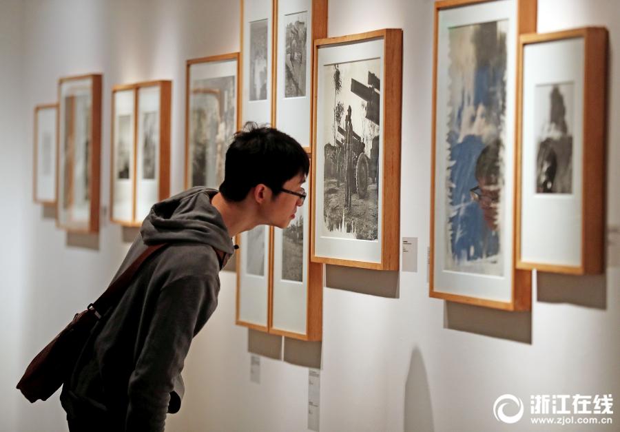 A visitor appreciates photography works at an exhibition at the art museum of the China Academy of Art in Hangzhou, Zhejiang Province, on April 3. (Photo/zjol.com.cn)
