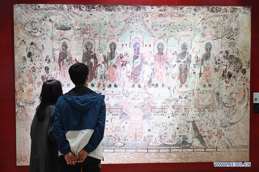 Visitors view a fresco during a Dunhuang fresco itinerant exhibition in Yunnan University in Kunming, southwest China\'s Yunnan Province, April 10, 2019. A Dunhuang fresco itinerant exhibition, with the participation of nearly 50 frescoes, was held in Yunnan University in Kunming Wednesday. (Xinhua/Qin Qing)