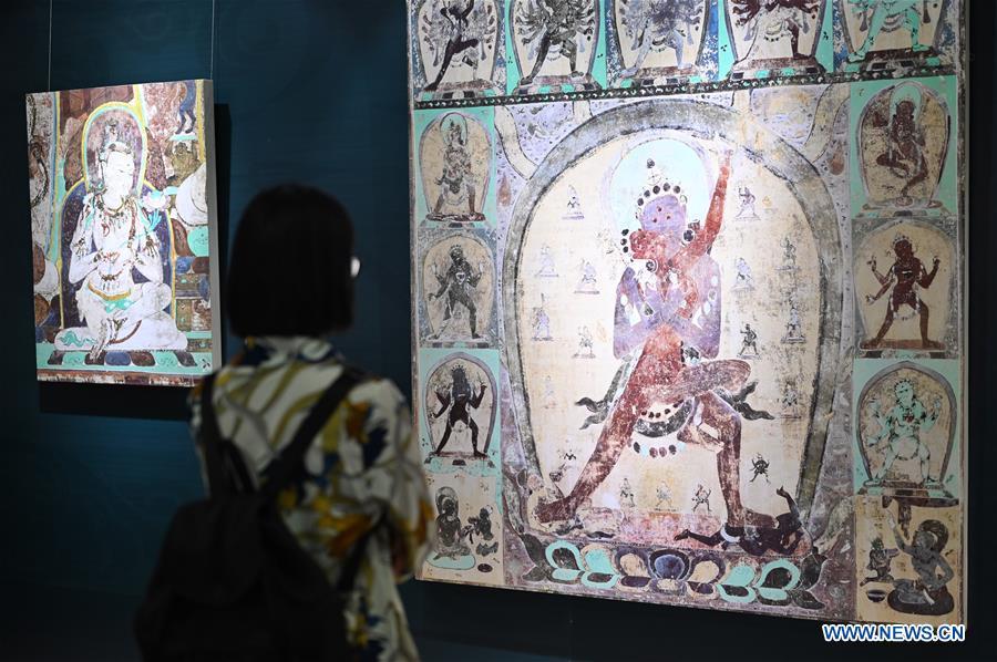 A visitor views frescoes during a Dunhuang fresco itinerant exhibition in Yunnan University in Kunming, southwest China\'s Yunnan Province, April 10, 2019. A Dunhuang fresco itinerant exhibition, with the participation of nearly 50 frescoes, was held in Yunnan University in Kunming Wednesday. (Xinhua/Qin Qing)