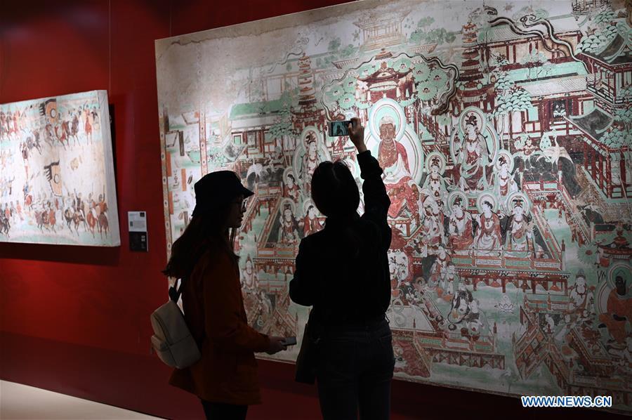 Visitors view a fresco during a Dunhuang fresco itinerant exhibition in Yunnan University in Kunming, southwest China\'s Yunnan Province, April 10, 2019. A Dunhuang fresco itinerant exhibition, with the participation of nearly 50 frescoes, was held in Yunnan University in Kunming Wednesday. (Xinhua/Qin Qing)