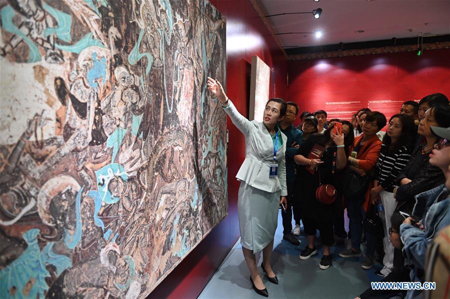 Ma Lin(L), a guide from Dunhuang Academy China, explains fresco culture to visitors during a Dunhuang fresco itinerant exhibition in Yunnan University in Kunming, southwest China\'s Yunnan Province, April 10, 2019. A Dunhuang fresco itinerant exhibition, with the participation of nearly 50 frescoes, was held in Yunnan University in Kunming Wednesday. (Xinhua/Qin Qing)