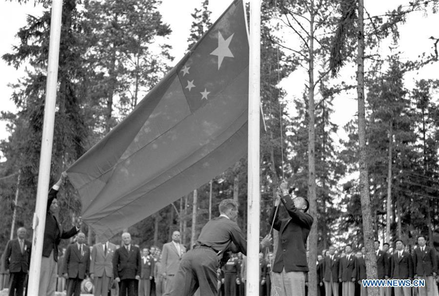 File photo taken on July 29, 1952 shows that a member of Chinese delegation hoisting the national flag in the Helsinki Olympic Athlete\'s Village. The 15th Summer Olympic Games took place in Helsinki, capital of Finland, from July 19 to August 3, 1952. The newly founded People\'s Republic of China sended a 40-member-delegation to the Games. From sending athletes to Helsinki Summer Olympic Games for the very first time in 1952 to winning the bid to host 2022 Winter Olympic Games in 2015, the People\'s Republic of China went through a remarkable history of sports, including successfully hosting the 2008 Summer Olympic Games and preparing for the upcoming 2022 Winter Olympic Games. (Xinhua)