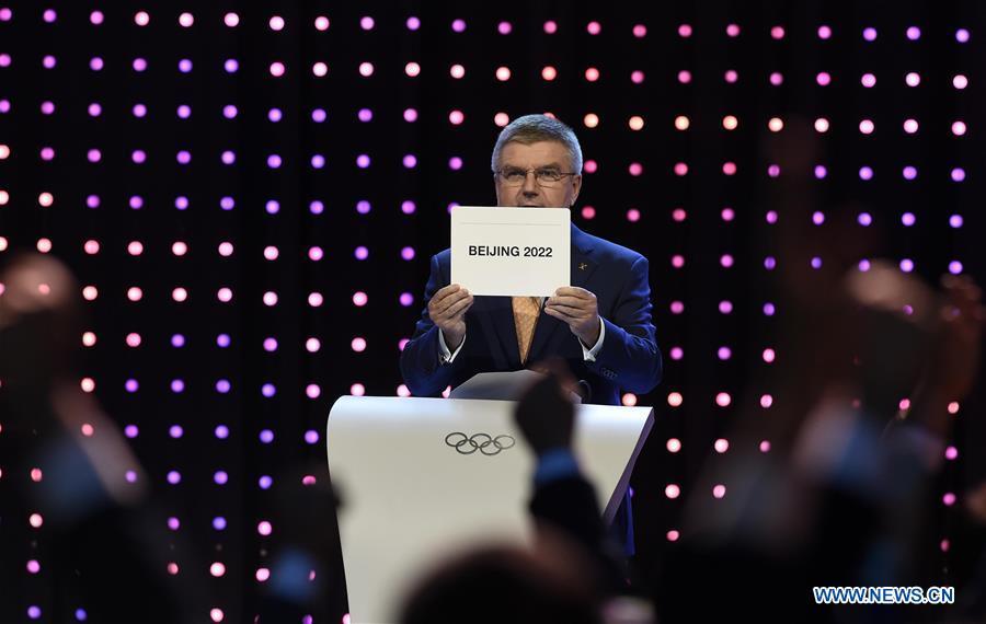 File photo taken on July 31, 2015 shows International Olympic Committee (IOC) president Thomas Bach shows the card with the name Beijing as the winning name of the 2022 Winter Olympic bid city, during the 128th International Olympic Committee (IOC) session in Kuala Lumpur, Malaysia. From sending athletes to Helsinki Summer Olympic Games for the very first time in 1952 to winning the bid to host 2022 Winter Olympic Games in 2015, the People\'s Republic of China went through a remarkable history of sports, including successfully hosting the 2008 Summer Olympic Games and preparing for the upcoming 2022 Winter Olympic Games. (Xinhua/Gong Lei)