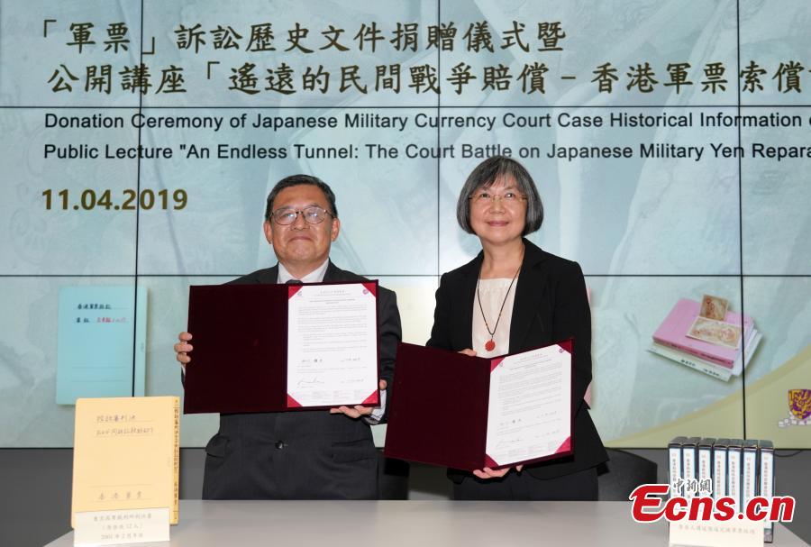 Mr. Wani Yukio (L) and Dr. Maria Lau sign donation papers at a ceremony at the Chinese University of Hong Kong Library in Hong Kong, April 11, 2019. In the 1990s, he formed a group with several Japanese lawyers and scholars to support a lawsuit, filed by victims in Hong Kong, seeking reparation for the military yen issued during the Japanese occupation. This is the only legal action ever taken by the Hong Kong community, and it was eventually rejected by the Supreme Court of Japan in 2001. After the legal action ended, Mr. Wani gathered the materials and information related to the case, including seven boxes of court judgments, case summaries, oral histories of victims in Hong Kong, news reports, and video tapes, and donated them to the CUHK Library, according to the library. (Photo: China News Service/Zhang Wei)