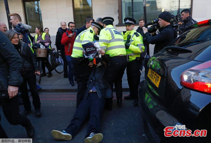 A demonstrator is carried away by police officers after trying to stop a vehicle as it leaves Westminster magistrates court where WikiLeaks founder Julian Assange was appearing in London, April 11, 2019.(Photo/Agencies)