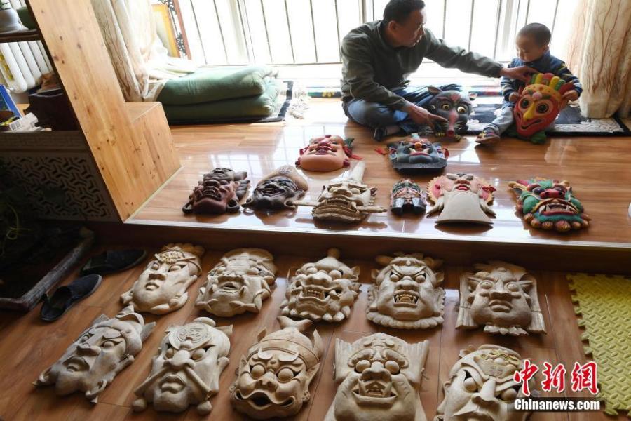 Ma Lande shows masks of the Nuo Opera at his studio in Lanzhou City, Northwest China\'s Gansu Province, April 14, 2019. The handicraftsman said he has made more than 2,000 Nuo Opera masks in the past 17 years, depicting a broad range of topics, including mythical figures from Chinese legends and classic novels. Masks, usually carved out of willow or camphor wood, are an important part of Nuo Opera, an ancient folk drama still popular in some parts of China. The purpose of Nuo Opera is to drive away devils, disease and evil influences, and also to petition the gods for their blessings. (Photo: China News Service/Yang Yanmin)