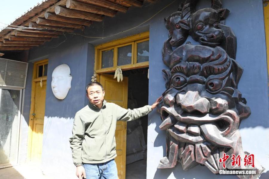 Ma Lande shows masks of the Nuo Opera at his studio in Lanzhou City, Northwest China\'s Gansu Province, April 14, 2019. The handicraftsman said he has made more than 2,000 Nuo Opera masks in the past 17 years, depicting a broad range of topics, including mythical figures from Chinese legends and classic novels. Masks, usually carved out of willow or camphor wood, are an important part of Nuo Opera, an ancient folk drama still popular in some parts of China. The purpose of Nuo Opera is to drive away devils, disease and evil influences, and also to petition the gods for their blessings. (Photo: China News Service/Yang Yanmin)