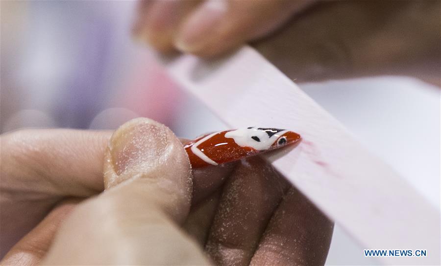 A competitor buffs a nail during the Nail Art Challenge at the 2019 Revel in Beauty event in Toronto, Canada, on April 15, 2019. The Nail Art Challenge was held on Monday to showcase the creative process of nail art to spectators. (Xinhua/Zou Zheng)