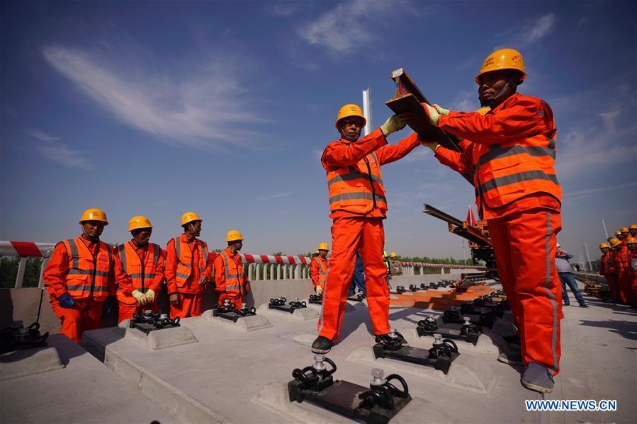 Builders of China Railway 12th Bureau Group work on the Liying section of the Beijing-Xiongan intercity railway, April 15, 2019. Track-laying work of the Beijing-Xiongan intercity railway began on Monday. (Xinhua/Xing Guangli)