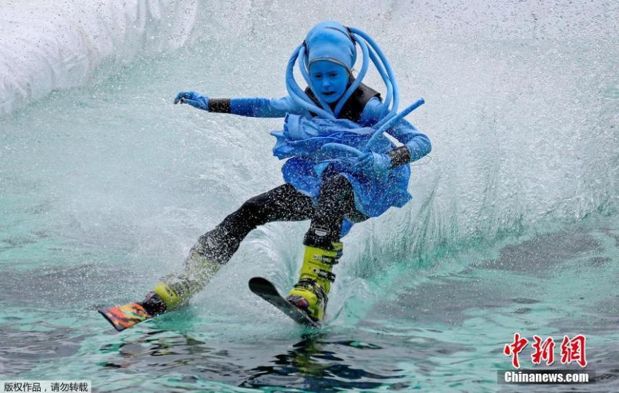 A costumed skier attempts to cross a pool of water at the foot of a ski slope during the annual Gornoluzhnik amateur event to mark the end of the ski season at the Bobrovy Log ski resort in Krasnoyarsk, Russia, April 14, 2019. (Photo/Agencies)