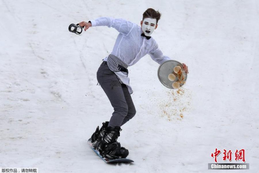 A costumed snowboarder glides down in attempt to cross a pool of water at the foot of a ski slope during the annual Gornoluzhnik amateur event to mark the end of the ski season at the Bobrovy Log ski resort in Krasnoyarsk, Russia, April 14, 2019. (Photo/Agencies)