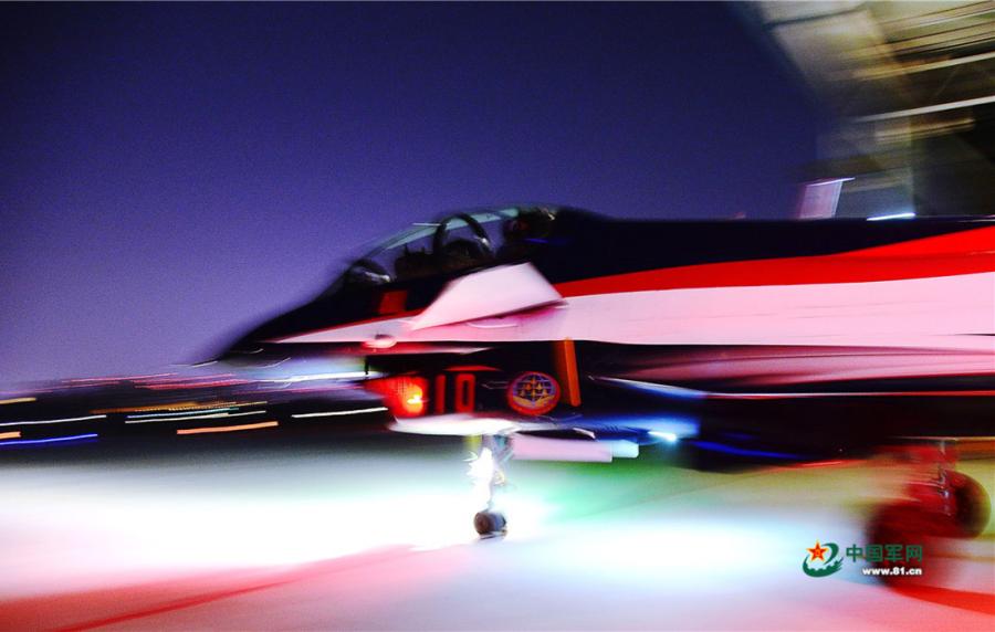 The moment when a plane, piloted by Zhang Chunlei, a member of the Chinese PLA Air Force\'s August 1st aerobatic team, glides out of a hangar on the night of April 12, 2019. (Photo/81.cn)