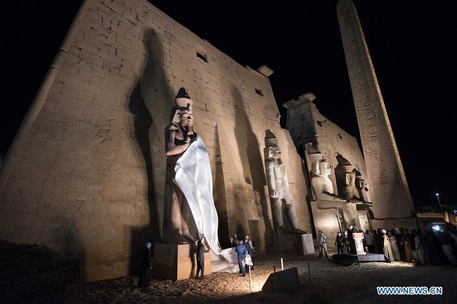 People attend the unveiling of a colossus of ancient Egyptian King Ramses II at Luxor Temple in Luxor, Egypt, April 18, 2019. Egypt\'s Ministry of Antiquities unveiled on Thursday evening a 60-ton statue of ancient Egyptian King Ramses II at the Luxor Temple after its restoration and re-erection on the Nile River\'s east bank in the southern province of Luxor. (Xinhua/Meng Tao)