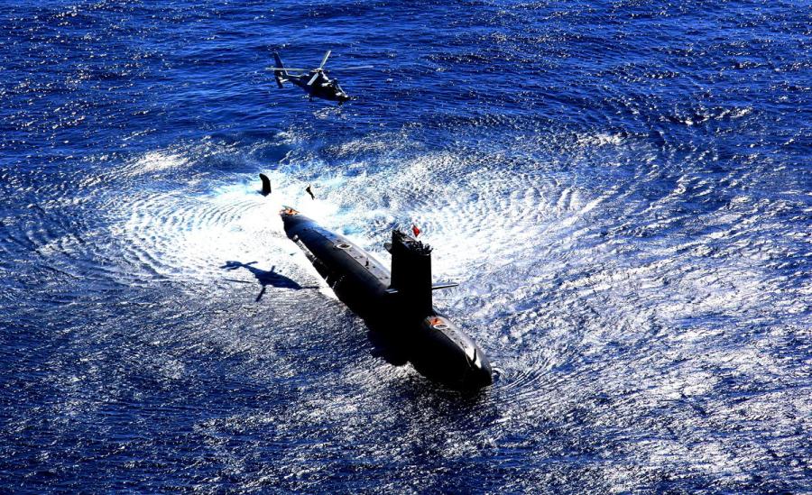 A helicopter and a submarine from a submarine division of the PLA Navy\'s South Sea Fleet participate in an exercise. (ZHOU YANCHENG/FOR CHINA DAILY)