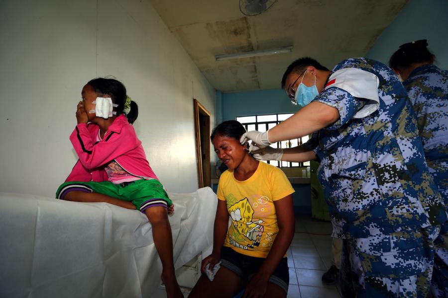 Ritchel Brogous, 29, and her daughter Jhasmen, 9, receive treatment from a doctor on the PLA Navy hospital ship Peace Ark in the Philippines. (JU ZHENHUA/FOR CHINA DAILY)