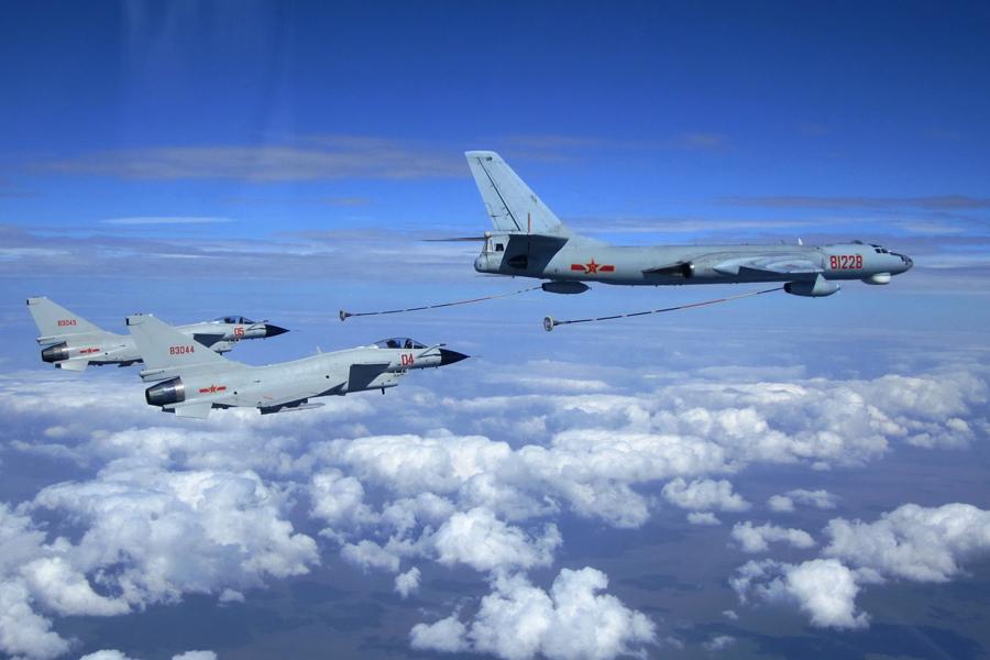 Two fighter jets from the PLA Navy prepare for aerial refueling from a tanker aircraft on July 28, 2014. (WU CHUANJUN/FOR CHINA DAILY)