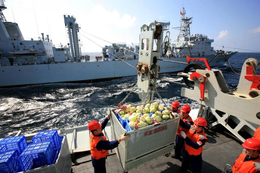 Crew members of a supply ship deliver food to a Navy warship. (LI TANG/FOR CHINA DAILY)