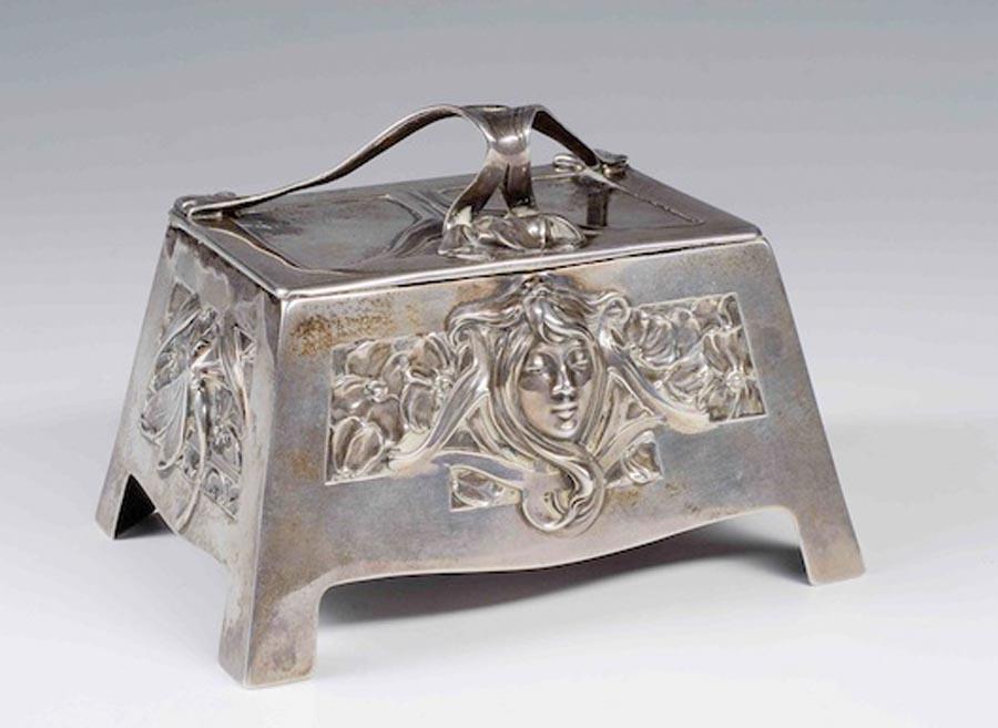 A silver box with the pattern of a girl\'s head that\'s named after Mucha. (Photo provided to China Daily)
During the exhibition, the Pearl Art Museum will organize a series of programs, including lectures and workshops presented by scholars and designers in art, history and culture. Lectures will also be held at colleges and universities around the Yangtze River Delta.

Gifts bearing Mucha designs, such as Czech crystal products, silk scarves, and other creative supplies, are available at the Life and Art boutique, or LAb, at the museum.

The museum has also compiled the exhibition catalogue Mucha in both Chinese and English. The book is available at LAb, its online store, as well as Xinhua Bookstores around China.