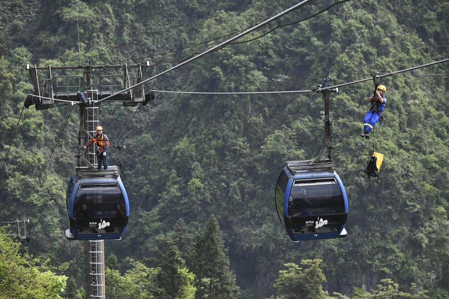 Rescue workers ride the ropeway to \