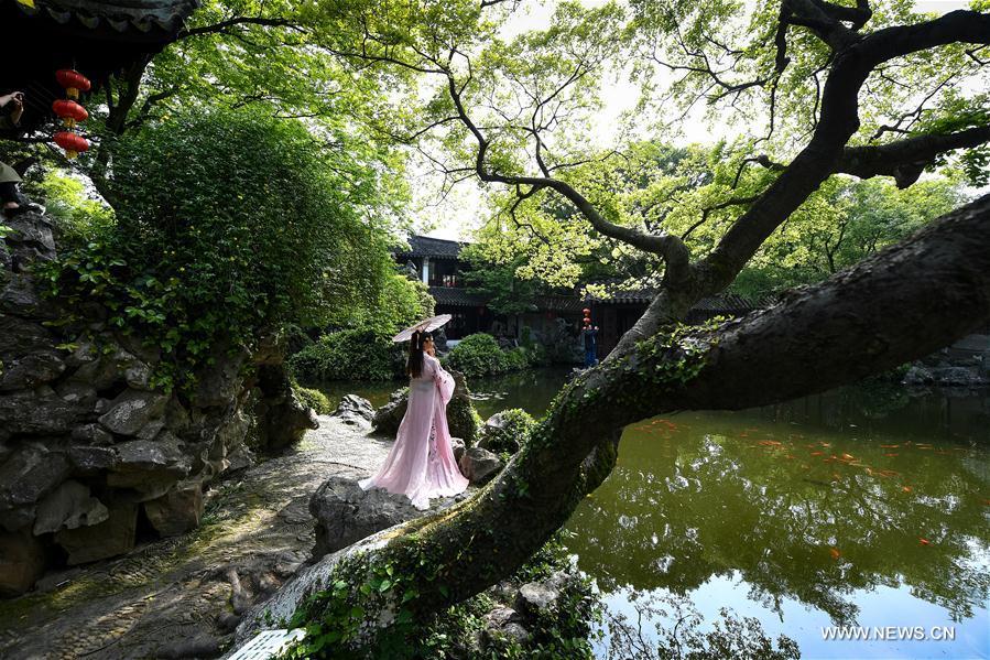 A woman poses for photos at the Retreat &Reflection Garden in Suzhou, east China\'s Jiangsu Province, April 19, 2019. Suzhou is home to dozens of famous classical gardens that have inventive and exquisite design and oriental aesthetics. Nowadays more than 60 of them are still in existence, among which the Humble Administrator\'s Garden, Lingering Garden and the Lion Grove Garden are on the UNESCO\'s World Heritage List. (Xinhua/Li Xiang)