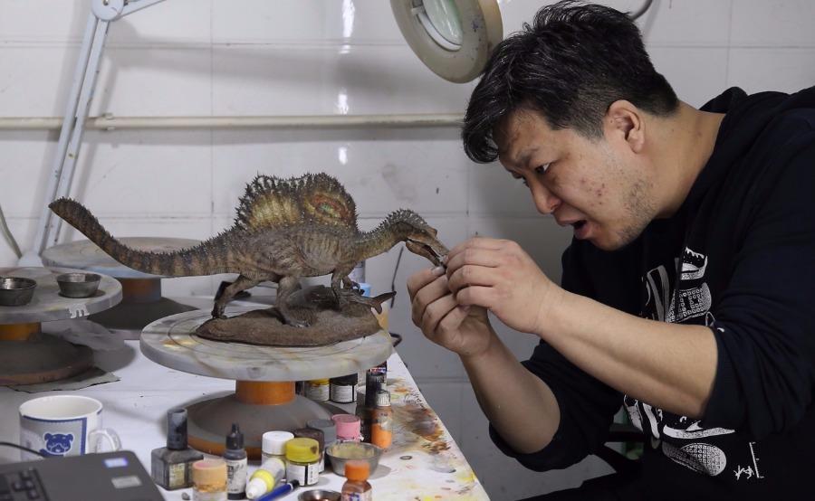 Zhao Chuang crayons gently the colors on a dinosaur model. (Photo/China Daily)
In 2006 when he was still in college, Zhao\'s drawing Restoration of Volaticotherium for a research piece was published as the cover of the British Nature magazine.

It was the first time that a Chinese artwork was chosen for the cover of the magazine.

After the publication of the picture on the magazine cover, Zhao won wide recognition from the paleontology community at home and abroad and has become a well-known science artist.