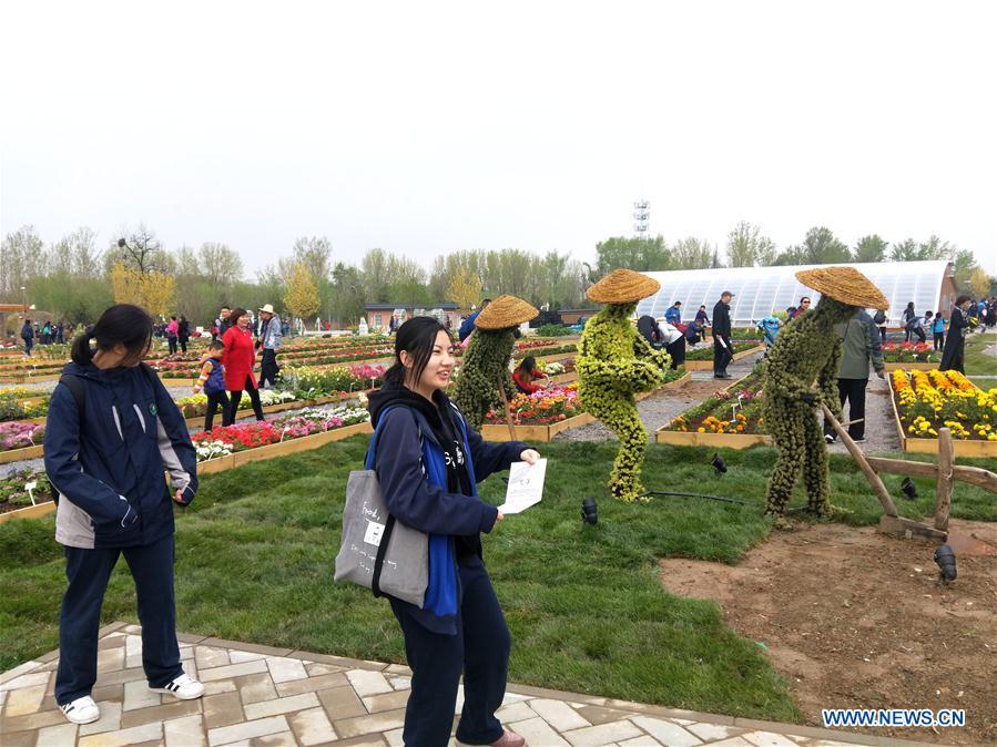 Photo taken with a mobile phone shows people visiting the 2019 Beijing International Horticultural Exhibition (Expo 2019 Beijing) venue during a trial run in Yanqing District of Beijing, capital of China, April 20, 2019. Beijing on Saturday held a trial opening of the site for the upcoming 2019 Beijing International Horticultural Exhibition to test the reception capacity of the event. About 60,000 people visited the 503-hectare expo site Saturday. (Xinhua/Wei Mengjia)