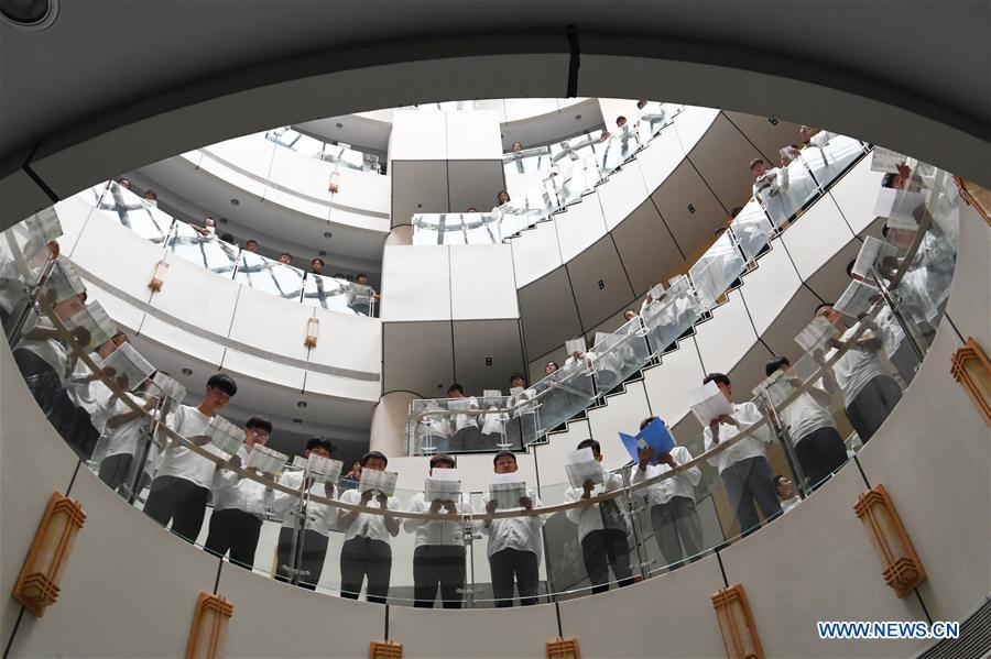 Students read poems in a flash mob activity in the library of Bozhou Vocational and Technical College in Bozhou City, east China\'s Anhui Province, April 21, 2019. Various activities have been held across China for the World Book Day, which is celebrated yearly on April 23 to promote reading, publishing and copyright. (Xinhua/Zhang Yanlin)