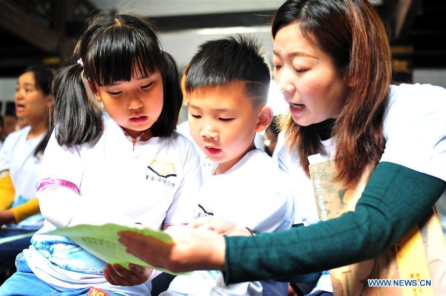 Children and a senior read a list of Chinese classics in Yiling District of Yichang City, central China\'s Hubei Province, April 21, 2019. Various activities have been held across China for the World Book Day, which is celebrated yearly on April 23 to promote reading, publishing and copyright. (Xinhua/Zhang Guorong)