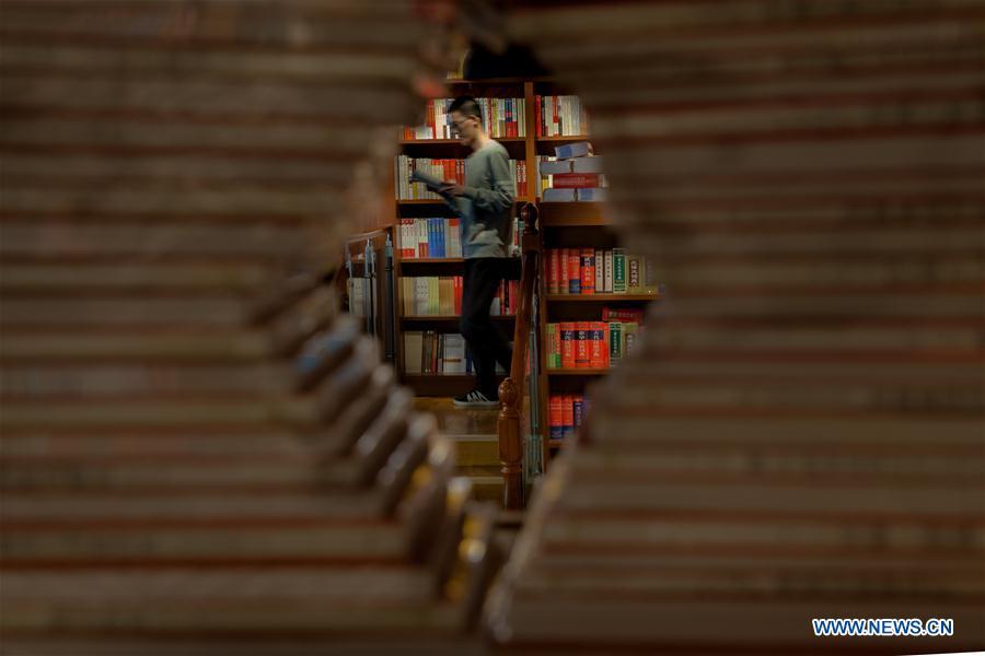 A reader reads a book in a bookstore in Gaoqing County, east China\'s Shandong Province, April 22, 2019. Various activities have been held across China for the World Book Day, which is celebrated yearly on April 23 to promote reading, publishing and copyright. (Xinhua/Zhang Weitang)