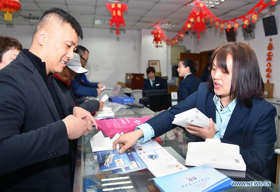 Citizens buy commemorative envelopes at a shop in Qingdao, east China\'s Shandong Province, April 23, 2019. A set of philatelic items were issued on Tuesday to mark the 70th founding anniversary of the Chinese People\'s Liberation Army (PLA) Navy. (Xinhua/Zhu Zheng)