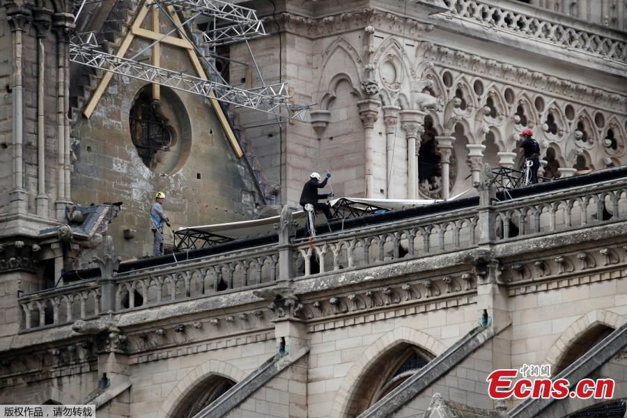 Workers placed giant tarpaulin coverings over Notre-Dame cathedral to protect its interior from the rain that was expected to hit Paris, April 23. 2019.  (Photo/Agencies)