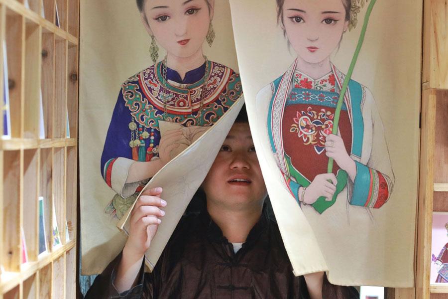 Lan Caisheng steps through curtains featuring his drawings in Zhaoxing Dong village, Liping county, Southwest China\'s Guizhou Province, April 16, 2019. (Photo/Xinhua)