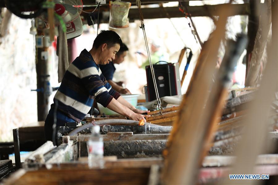 Wang Xingwu makes paper at a workshop in Shiqiao Village of Danzhai County, southwest China\'s Guizhou Province, April 24, 2019. Wang Xingwu, 53, a national intangible cultural heritage inheritor in papermaking, learned the papermaking technique from his family as a child. Besides exerting the old papermaking technique to its full potential, Wang keeps raising product quality and improving the making procedure. With the involvement of plants in the papermaking process, he has created more than 160 kinds of patterned papers and paper crafts. He also develops a kind of handmade white paper more suitable for writing calligraphy and painting. (Xinhua/Huang Xiaohai)