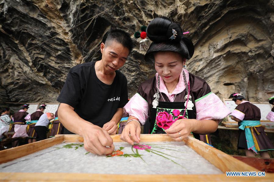 Wang Xingwu (L), a papermaker, teaches a villager to make patterned paper at a workshop in Shiqiao Village of Danzhai County, southwest China\'s Guizhou Province, Sept. 7, 2017. Wang Xingwu, 53, a national intangible cultural heritage inheritor in papermaking, learned the papermaking technique from his family as a child. Besides exerting the old papermaking technique to its full potential, Wang keeps raising product quality and improving the making procedure. With the involvement of plants in the papermaking process, he has created more than 160 kinds of patterned papers and paper crafts. He also develops a kind of handmade white paper more suitable for writing calligraphy and painting. (Xinhua/Huang Xiaohai)