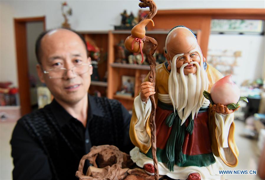 Chen Hailiang shows a dough sculpture he made in Yongqing County, north China\'s Hebei Province, April 28, 2019. Chen Hailiang, 52, is a folk artist of dough sculpture in Yongqing County. He started learning dough sculpture making when he was young and won prizes for his unique style. (Xinhua/Wang Xiao)