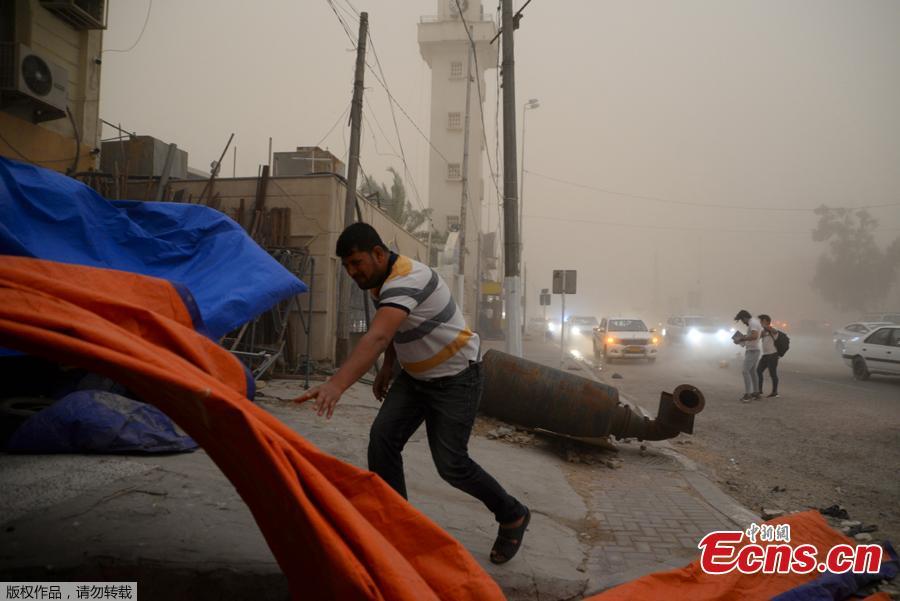 A man walks near a wind-toppled motorcycle in Iraq\'s central city of Najaf during a sand storm on, April 29, 2019. (Photo/Agencies)