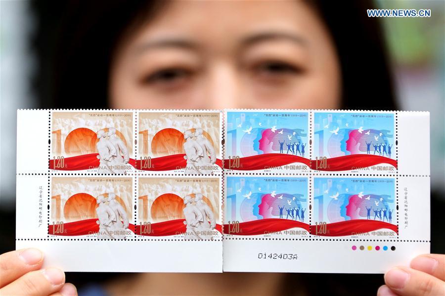 A stuff member of the Zaozhuang branch office of China Post shows the commemorative stamps for the 100 anniversary of the May 4th Movement, in Zaozhuang City, east China\'s Shandong Province, May 4, 2019. China Post on Saturday issued a set of two commemorative stamps marking the 100 anniversary of the May Fourth Movement. (Xinhua/Sun Zhongzhe)