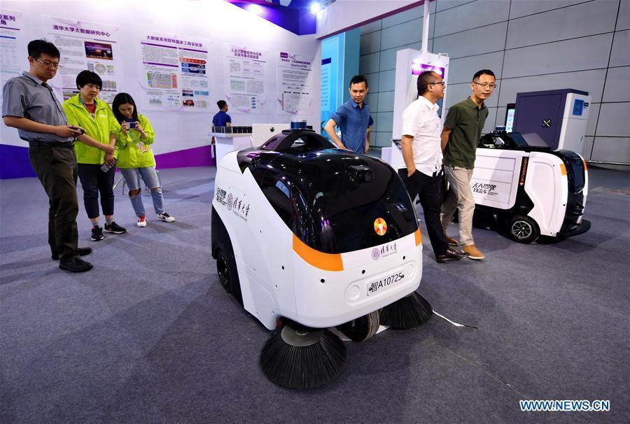 Visitors look at an auto-pilot cleaning vehicle (L) and an auto-pilot logistics vehicle at the 2nd Digital China Exhibition in Fuzhou, southeast China\'s Fujian Province, May 5, 2019. The 2nd Digital China Exhibition runs from May 5 to 9 at the Fuzhou Strait International Conference & Exhibition Center. (Xinhua/Lin Shanchuan)
