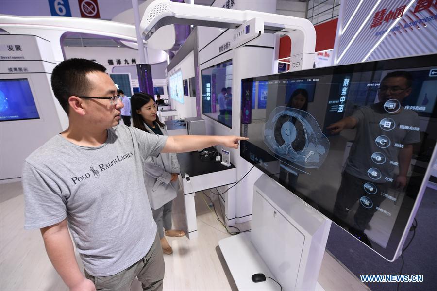 A staff from Tsinghua-Fuzhou Institute for Data Technology shows a multi-modal interactive system which displays medical images at the 2nd Digital China Exhibition in Fuzhou, southeast China\'s Fujian Province, May 5, 2019. The 2nd Digital China Exhibition runs from May 5 to 9 at the Fuzhou Strait International Conference & Exhibition Center. (Xinhua/Lin Shanchuan)