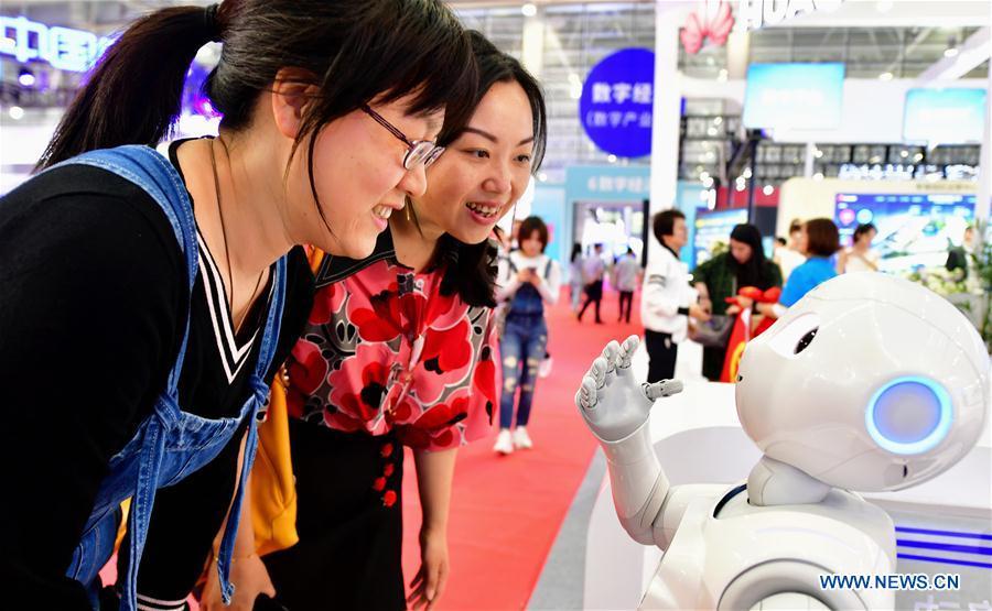 Two visitors interact with a robot at the 2nd Digital China Exhibition in Fuzhou, southeast China\'s Fujian Province, May 5, 2019. The 2nd Digital China Exhibition runs from May 5 to 9 at the Fuzhou Strait International Conference & Exhibition Center. (Xinhua/Wei Peiquan)