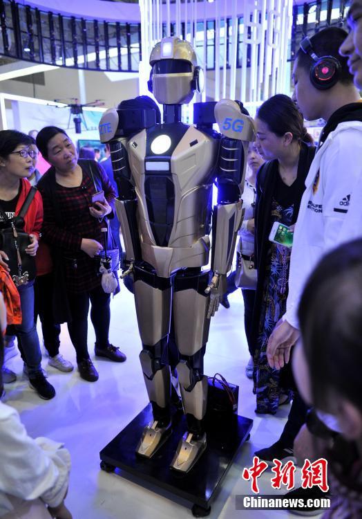 Visitors look at a 5G-powered robot at the ZTE booth during the second Digital China Summit in Fuzhou, East China\'s Fujian Province, May 6, 2019. (Photo: China News Service/Zhang Bin)