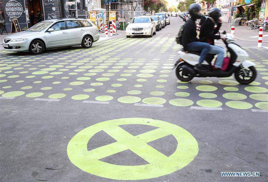 Vehicles drive across a green dotted street area in Bergmann Street of Kreuzberg, southern Berlin, Germany, on May 7, 2019. The green dots, part of new street signals in Berlin, are applied as a trial at a part of Bergmann Street with a speed limit of 20km/h, aiming to induce vehicles to drive with restricted speed. (Xinhua/Shan Yuqi)