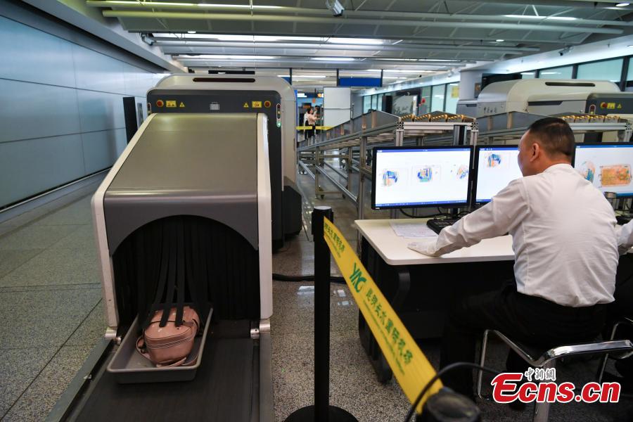 A Kunming Customs officer checks a passenger\'s luggage using a scanner at the Changshui International Airport in Kunming City, Yunnan Province, May 8, 2019. Kunming Customs showcased endangered species and wildlife products seized by staff at the airport. (Photo: China News Service/Ren Dong)