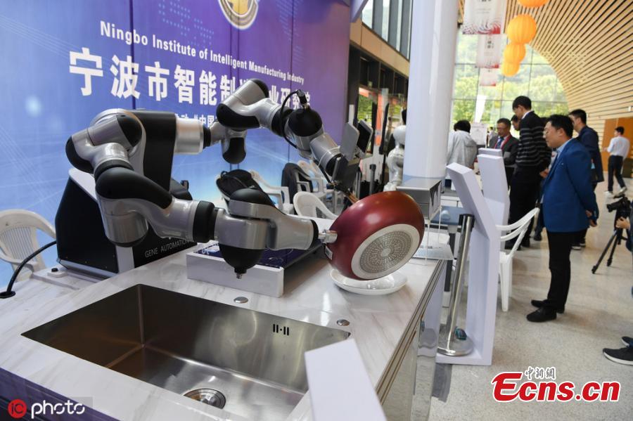 A robot performs tasks including writing calligraphy with a brush, cooking, and delivering beer after opening a bottle all on its own during the 6th China Robotop Summit in Ningbo City, East China\'s Zhejiang Province, May 9, 2019. According to its official website, the summit aims to promote the application of robots in intelligent manufacturing. (Photo/IC)